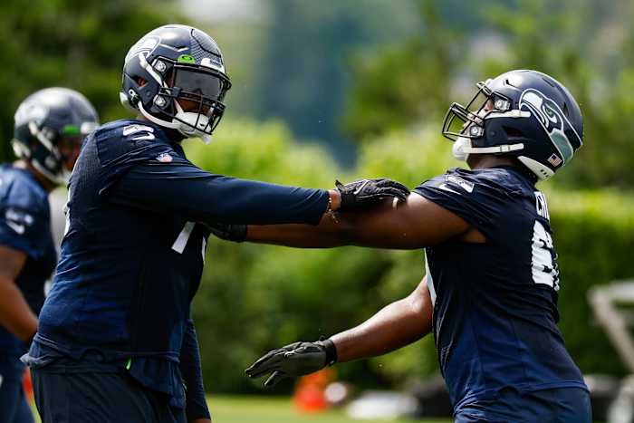 Seattle Seahawks tackle Greg Eiland (75, left) and offensive tackle Charles Cross (67, right) participate in a drill during minicamp practice at the Virginia Mason Athletic Center Field.